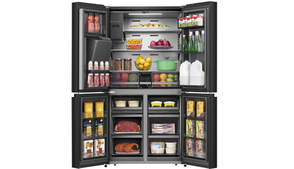 Czarna lodówka z otwartymi drzwiami, ukazująca wnętrze z różnorodnymi produktami spożywczymi, w tym napojami, owocami, warzywami i nabiałem. Na górnej części widoczne jest logo \'Hisense\'.