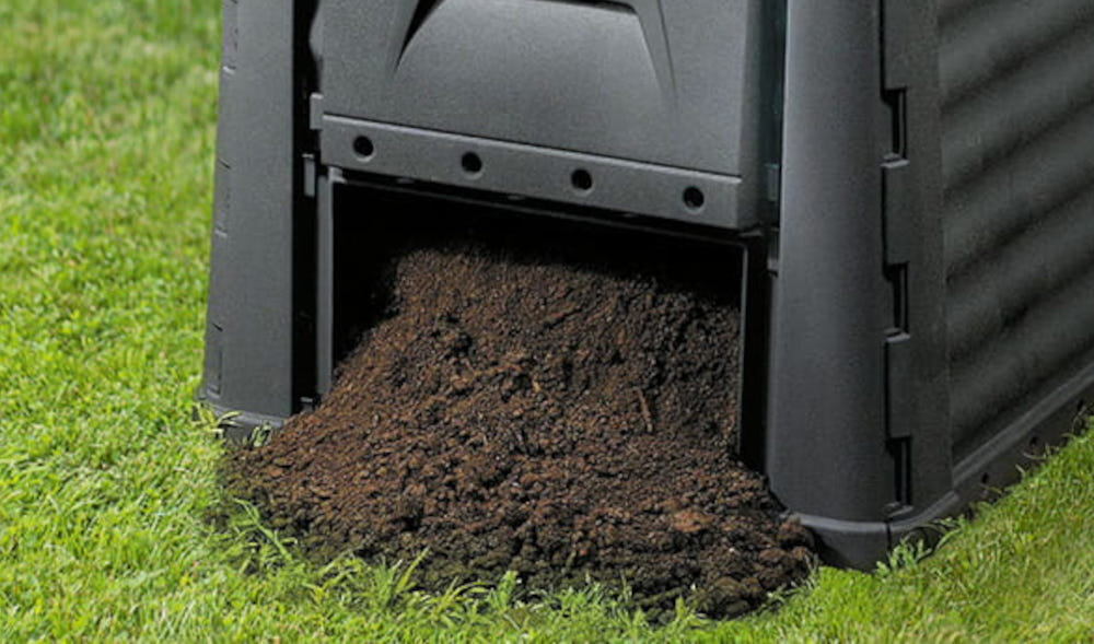 Kompostownik KETER ECO 320 l Czarny zbliżenie na dolny otwór z wysypującą się ziemią pojemność 320 litrów gromadzenie dużej ilości odpadów organicznych ekologiczny kompost dolny otwór łatwy dostęp do gotowego kompostu