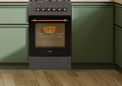 Zbliżenie na piekarni ze złotym uchwytem. W piekarniku ciasto.