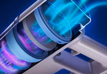 Obraz przedstawia przekrój odkurzacza z widocznym przepływem powietrza w kolorach niebieskim i fioletowym. Widać szczegóły konstrukcji wewnętrznej urządzenia.