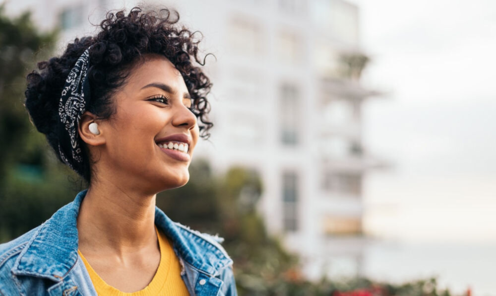 JBL Wave Buds 2 z aktywną redukcją hałasu ANC i trybem Smart Ambient, osoba z założonymi słuchawkami dokanałowymi