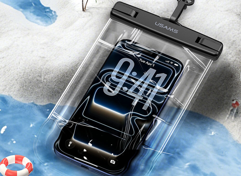 Etui wodoodporne USAMS YD016 IPX8 ochrona w wodzie Czarny wodoodporny etui na telefon marki USAMS leżący na piaszczystej plaży przy brzegu wody, chroniący smartfon przed piaskiem i wilgocią.