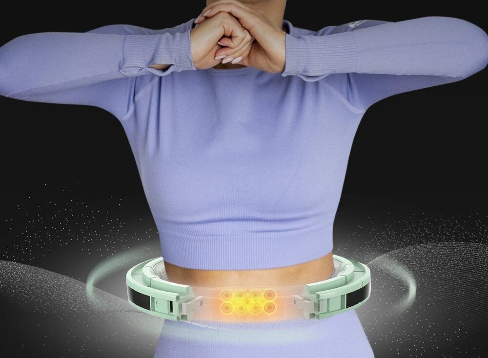 Osoba w fioletowym stroju używa zielonego hula hop z dodatkowymi elementami świetlnymi wokół talii. Tło jest ciemne, co podkreśla jasne elementy produktu.