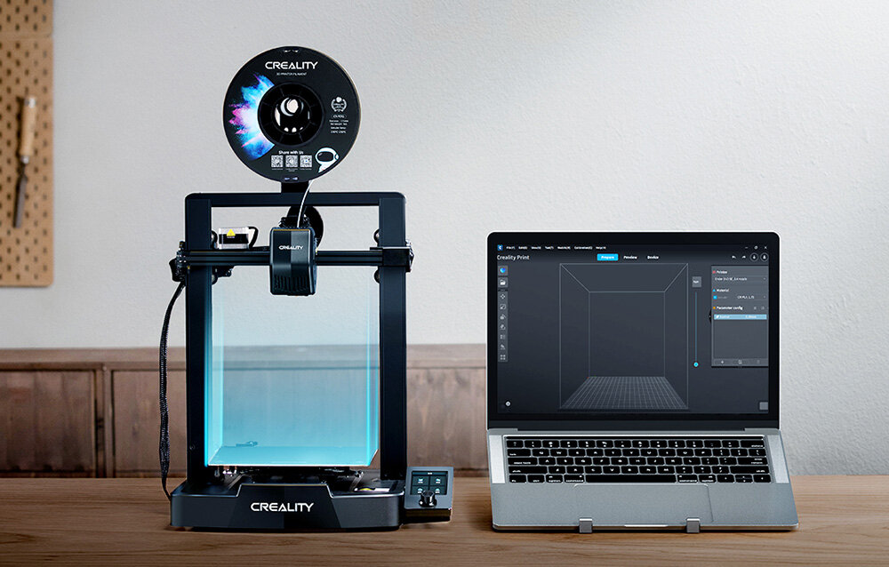 CREALITY Ender-3 V3 SE drukarka na blacie obok laptop z uruchomionym programem graficznym