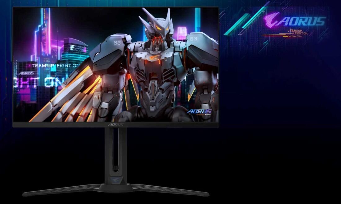 Monitor wyświetla obraz futurystycznego robota na tle neonowego miasta. Obok monitora widoczne jest logo \'AORUS\'.