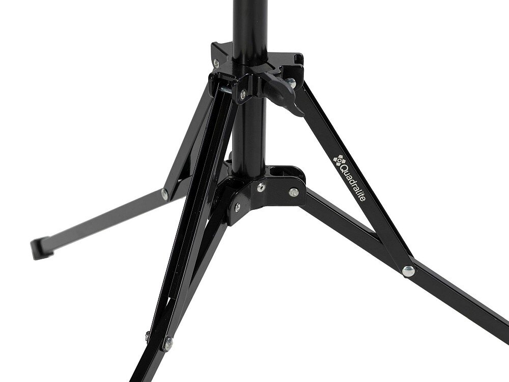 Czarny statyw oświetleniowy z widocznym logo \'Quadralite\' na jednej z nóg. Konstrukcja metalowa z kilkoma śrubami mocującymi.