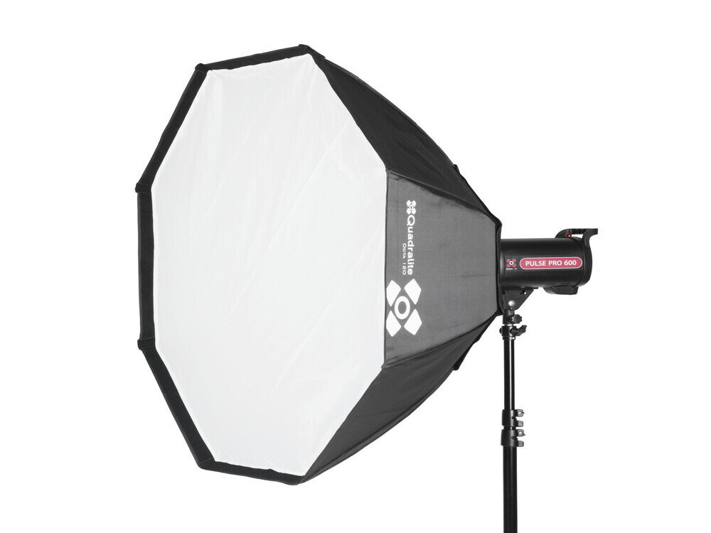 Na zdjęciu widoczny jest oktagonalny softbox z białą powierzchnią dyfuzyjną i czarnymi krawędziami, zamontowany na statywie. Na czarnej części softboxu znajduje się logo \'Quadralite\'.