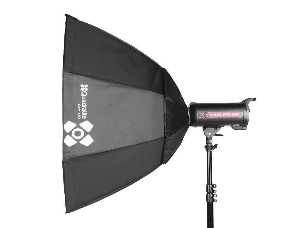 Na zdjęciu widoczny jest czarny softbox oktagonalny z logo \'Quadralite\' oraz lampa studyjna z napisem \'Pulse Pro 600\' zamocowana na statywie.