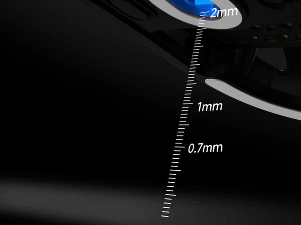 Obraz przedstawia zbliżenie na czarną powierzchnię z niebieskim elementem oraz miarką z oznaczeniami 0.7mm, 1mm i 2mm.