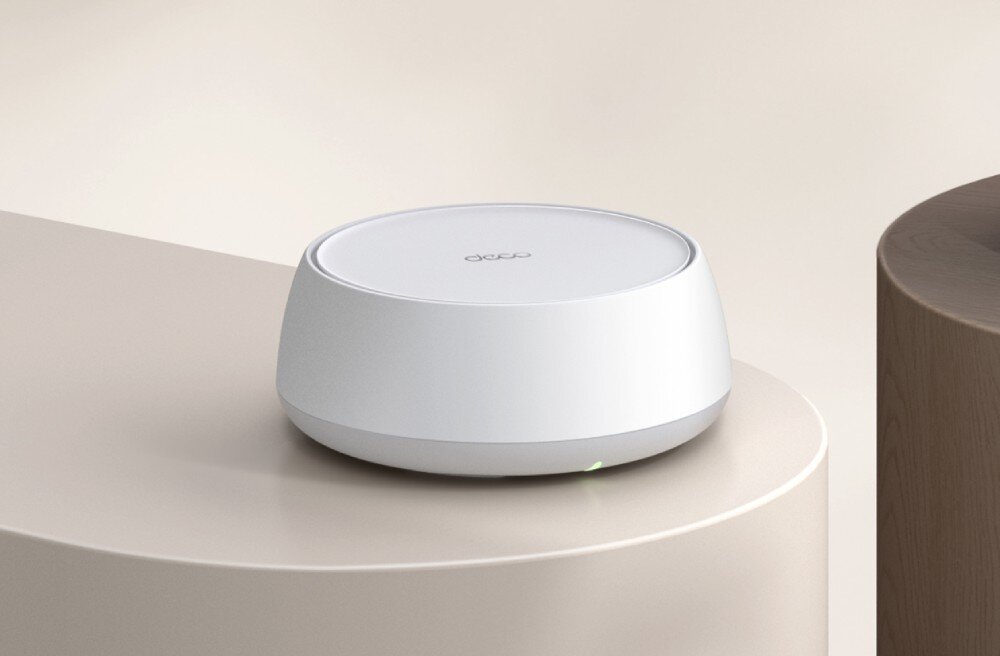 Router TP-LINK Deco BE22 okrągłe urządzenia sieciowe ustawione na dwóch nowoczesnych stolikach w jasnym wnętrzu, opis