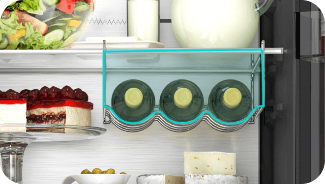 Wnętrze lodówki z trzema butelkami wina na specjalnej półce, obok znajdują się ciasta, ser i oliwki. Na górnej półce widoczny jest dzbanek i inne produkty spożywcze.