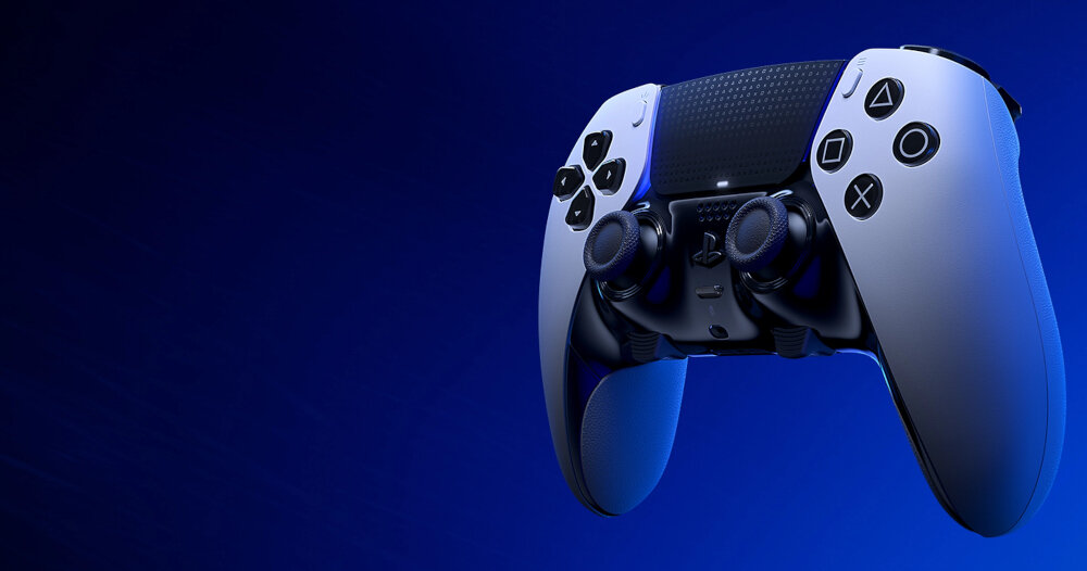 Na obrazie widoczny jest biało-czarny kontroler do gier z charakterystycznymi przyciskami i gałkami analogowymi. Tło jest jednolite, w odcieniu ciemnego niebieskiego.