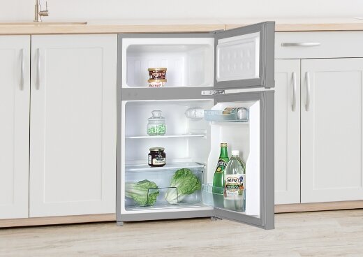 Otwarta lodówka MPM-87-CZ-13/E w zabudowie kuchennej. W urządzeniu artykuły spożywcze.