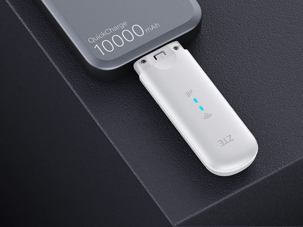 Modem ZTE MF79N 4G LTE Biały adapter do ładowania bezprzewodowego z niebieskimi diodami LED, podłączony do powerbanku, symbolizuje mobilny internet i wygodne zasilanie w podróży, standard, przepustowość, złacze