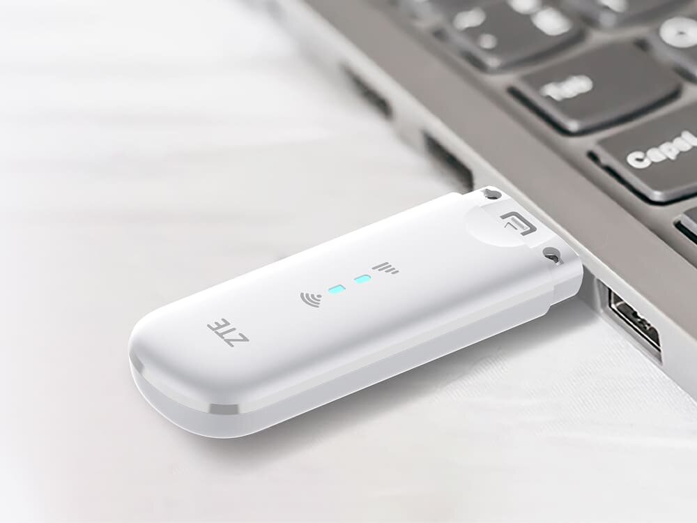 Modem ZTE MF79N 4G LTE Biały modem ZTE MF79U podłączony do laptopa, z widocznym symbolem Wi-Fi i niebieskimi diodami. Obraz ilustruje prostą, automatyczną instalację urządzenia bez dodatkowych sterowników, sterowniki, instalacja, kompatybilność