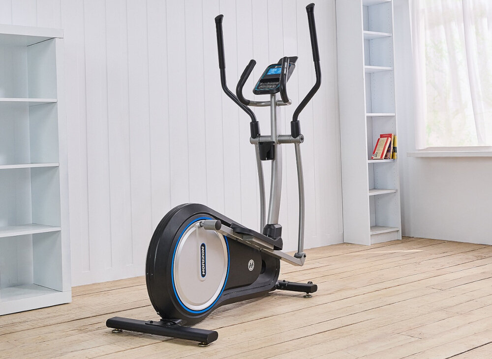 Orbitrek eliptyczny w jasnym pomieszczeniu z drewnianą podłogą i białymi ścianami. Na urządzeniu widoczne jest logo \'HORIZON\'.