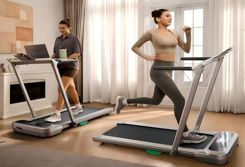 Bieżnia elektryczna UREVO Foldmix 5L Pro 2237W 13.4 km-h pokój dwie osoby trenują na dwóch bieżniach na jednej osoba idzie na drugiej biegnie w tle okno firany tryb chodzenia (1–6 km/h) tryb biegania (do 13,4 km/h) lekkie rozgrzewki bardziej intensywne sesje cardio wysokość pasa biegowego można regulować w zakresie 0–9% regulacja tempa i nachylenia wspiera stopniowe budowanie formy zmniejsza ryzyko przeciążenia