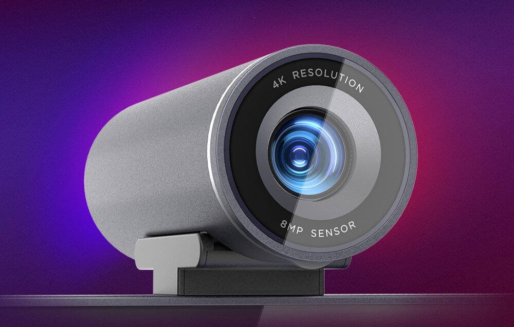 Obraz przedstawia kamerę o cylindrycznym kształcie z napisem \'4K RESOLUTION 8MP SENSOR\' wokół obiektywu. Tło jest gradientowe, w odcieniach fioletu i różu.