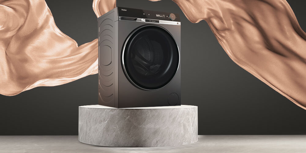 PRALKA HAIER HW100BD14397PGUS X11 lifestyle wizualizacja pralka na betonowym podeście bok zamknięta elementy dekoracyjne antracytowy kolor wygląd styl komfort wysoka jakość