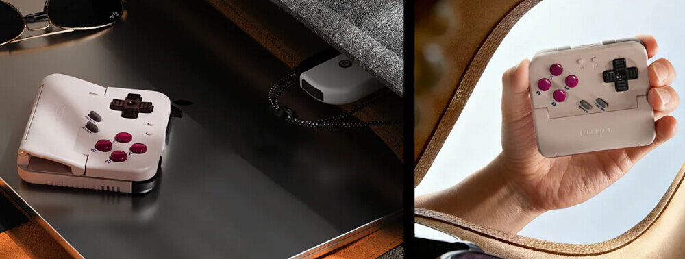 Na obrazie widoczny jest biały kontroler z różowymi przyciskami i czarnym krzyżakiem, leżący na powierzchni oraz trzymany w dłoni. W tle znajduje się szara tkanina i brązowy materiał.