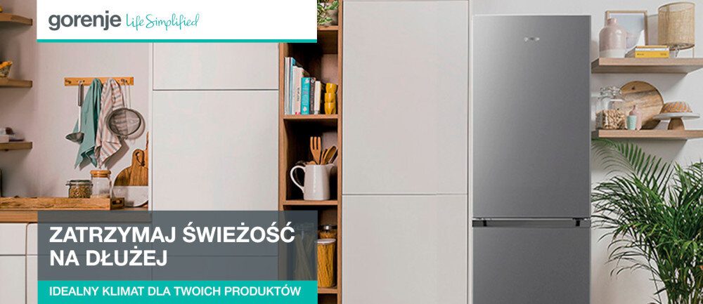 Obraz przedstawia szarą lodówkę w kuchni z drewnianymi półkami i białymi szafkami. Na obrazie widoczny jest tekst: \'ZATRZYMAJ ŚWIEŻOŚĆ NA DŁUŻEJ IDEALNY KLIMAT DLA TWOICH PRODUKTÓW\'.