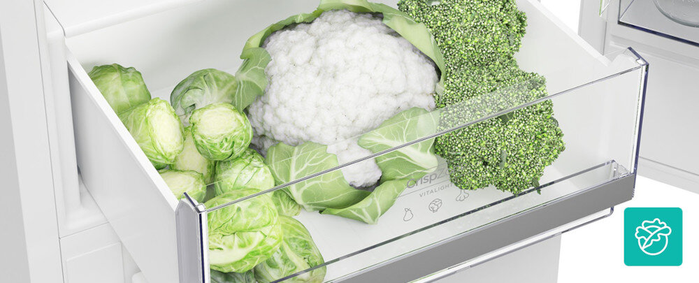 Wnętrze szuflady lodówki z warzywami: kalafiorem, brokułem i brukselką. Na szufladzie widoczny jest napis \'CRISPZONE\'.