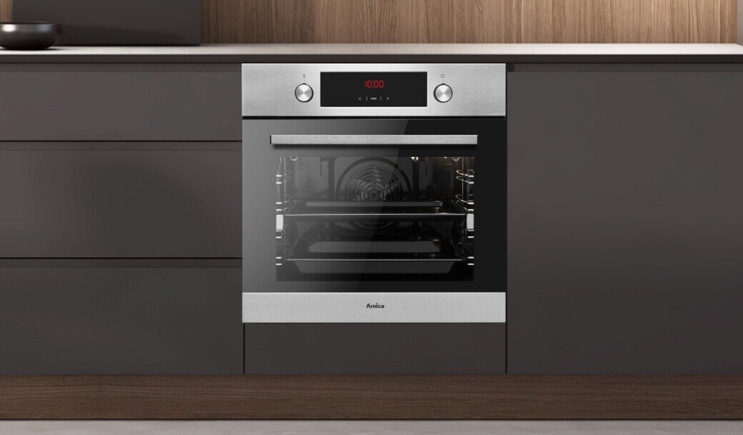 Piekarnik elektryczny w kolorze inox wbudowany w szafki kuchenne, z wyświetlaczem cyfrowym pokazującym \'12:00\'. Na froncie widoczne jest logo \'Amica\'.
