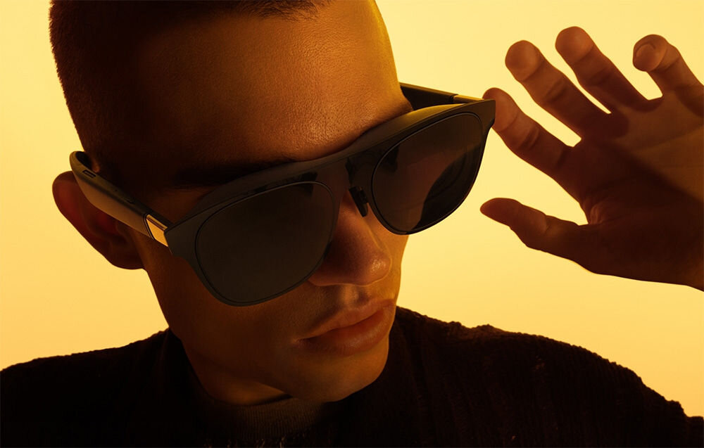 Okulary XREAL One Czarny prezentacja założonych okularów na mężczyźnie na żółtym tle powłoka antyrefleksyjna odporne na zarysowania filtr redukcja emisji światła niebieskiego ograniczenie zmęczenia oczu certyfikat TÜV Rheinland