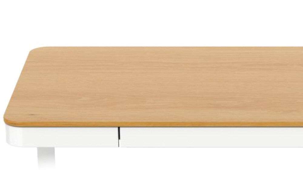 Blat biurka w kolorze brązowym z zaokrąglonymi rogami, osadzony na białej podstawie. Widoczna jest część szuflady pod blatem.