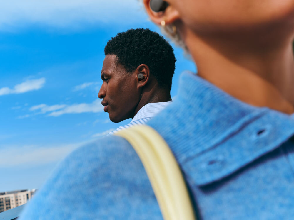 Słuchawki dokanałowe GOOGLE Pixel Buds 2a ANC osoba idąca ulicą aktywna redukcja szumów wyciszenie tryb dźwięków otoczenia