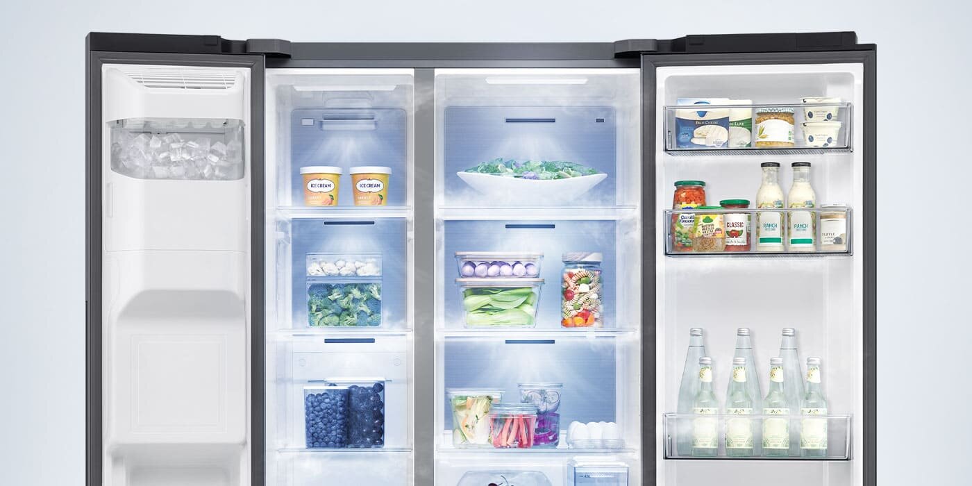 lodówka side by side rs70f65keteo z systemem chłodzenia mono Wnętrze lodówki z otwartymi drzwiami, wypełnione różnorodnymi produktami spożywczymi, takimi jak warzywa, napoje i nabiał. W lewej części widoczny jest podajnik lodu.