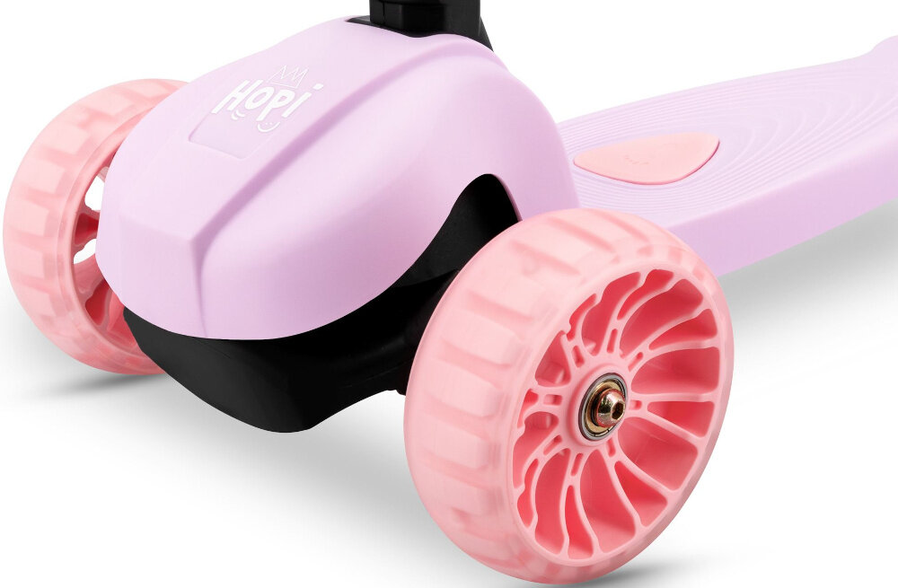 Różowa hulajnoga dziecięca z dwoma przednimi kołami w kolorze jasnoróżowym. Na przodzie widoczny jest napis \'Hopi\'.