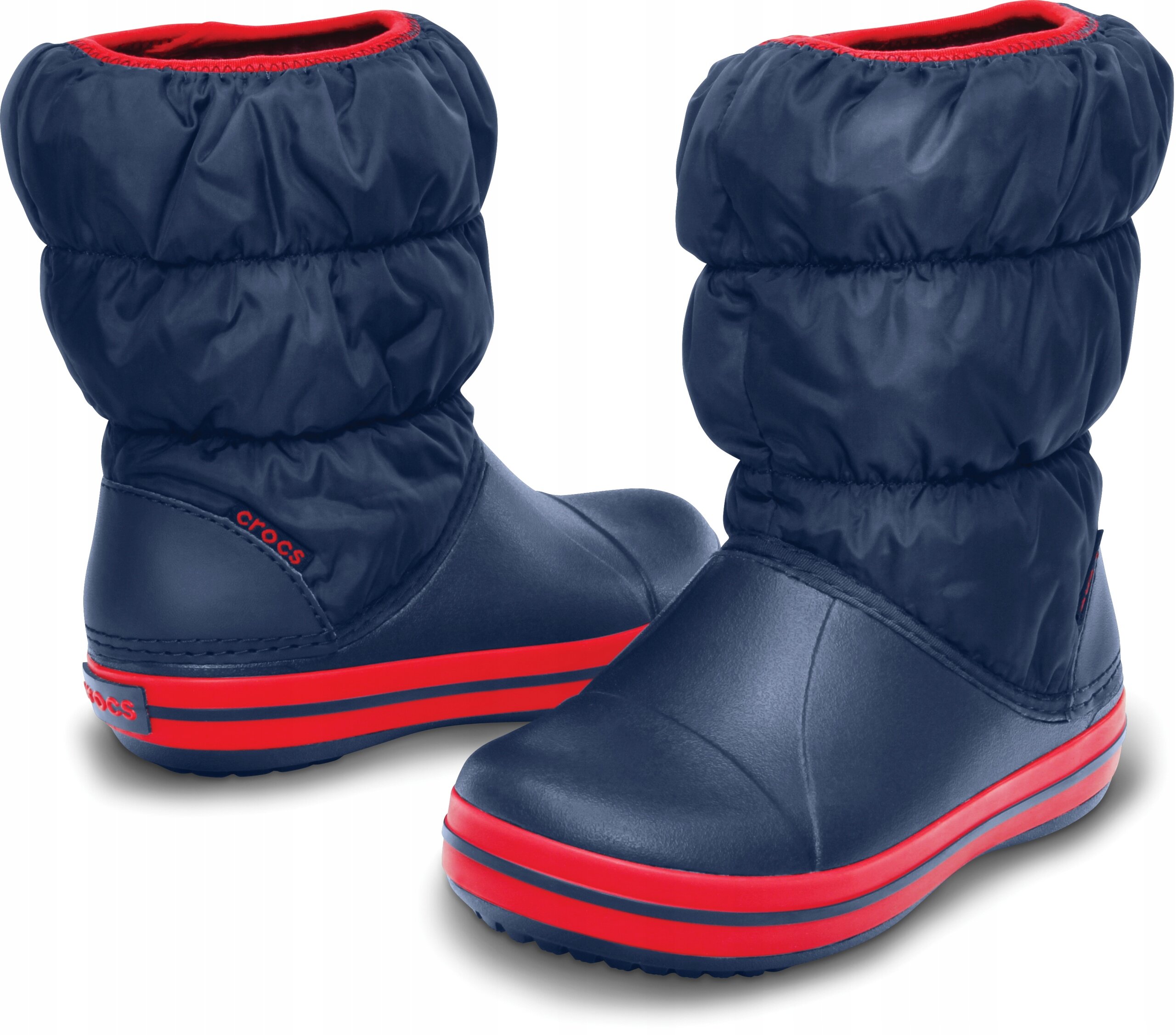 Dziecięce buty zimowe w kolorze granatowym z czerwonymi akcentami i logo \'crocs\' na boku. Buty mają puchate cholewki i gumowe podeszwy.