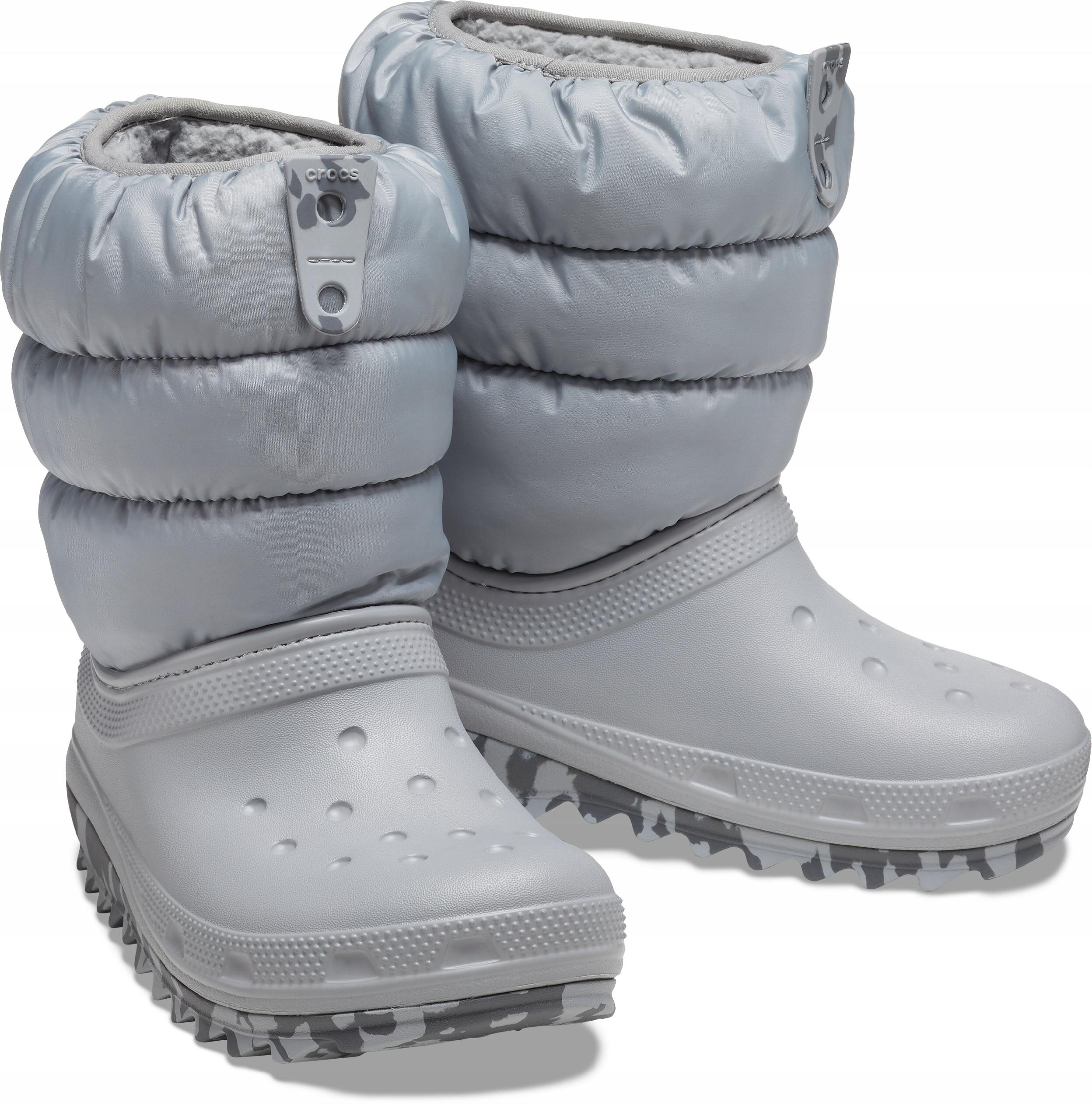 Na obrazie widoczne są dziecięce buty zimowe w kolorze szarym z pikowanymi cholewkami. Na górnej części butów znajduje się logo \'crocs\'.