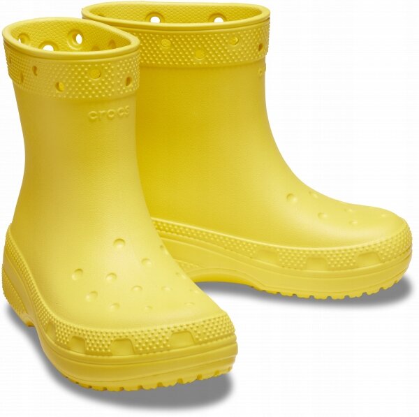 Żółte dziecięce kalosze z perforacjami i teksturą na górnej części oraz podeszwie. Na cholewce widoczne jest logo \'crocs\'.