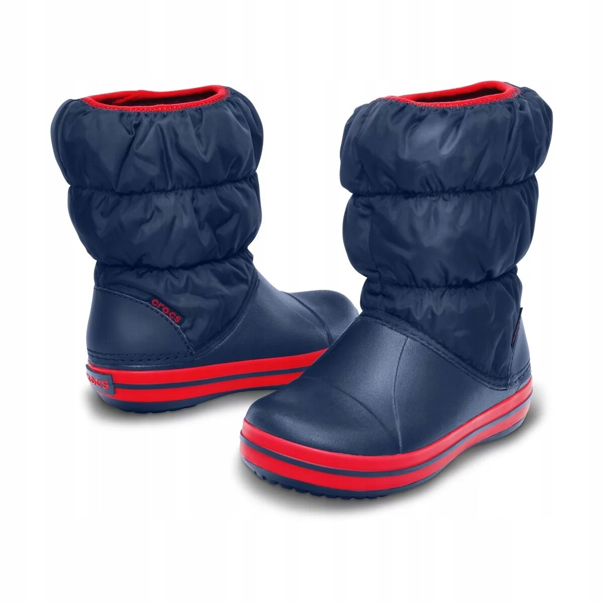 Dziecięce buty zimowe w kolorze granatowym z czerwonymi akcentami i logo \'crocs\' na boku. Buty mają puchate cholewki i gumowe podeszwy.