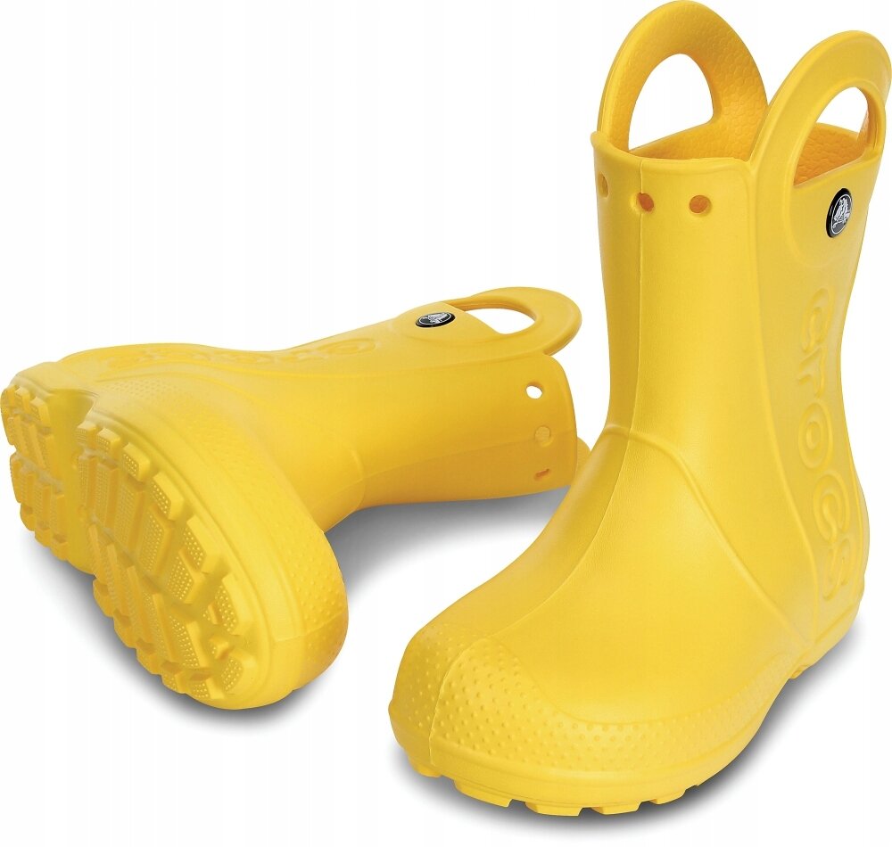 Na obrazie widoczne są żółte dziecięce kalosze z uchwytami, wykonane z gumowego materiału. Na jednym z butów znajduje się okrągłe logo z napisem \'Crocs\'.