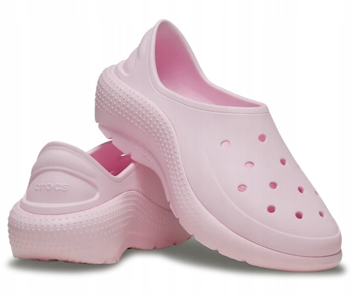 Różowe wsuwane buty sportowe z otworami na wierzchu i teksturą na podeszwie. Na tylnej części jednego z butów widoczne jest logo \'crocs\'.