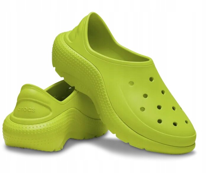 Dwa jasnozielone buty wsuwane z otworami na wierzchu i teksturą na podeszwie. Na jednym z butów widoczne jest logo \'crocs\'.