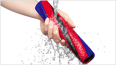 Ręka trzyma kolorowy element, który jest myty pod bieżącą wodą. Element ma czerwono-niebieskie barwy.