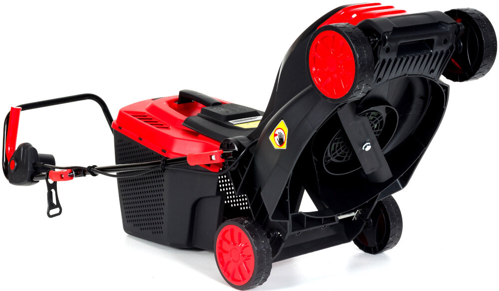 Kosiarka elektryczna z czerwonymi i czarnymi elementami, widoczna od spodu z widocznym ostrzem i kołami. Na obudowie znajduje się żółty symbol ostrzegawczy z ręką.