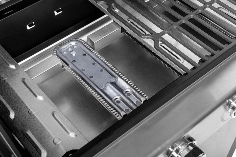 Zdjęcie przedstawia wnętrze grilla gazowego z widocznym palnikiem i rusztem. Elementy wykonane są z metalu, a na dole widoczne są pokrętła sterujące.