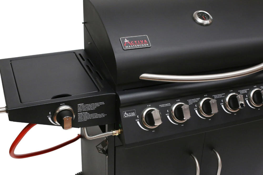 Czarny grill gazowy z logo \'ACTIVA Mastercook\' na pokrywie i sześcioma pokrętłami regulacyjnymi. Widoczny jest również termometr na pokrywie oraz boczny palnik z pokrętłem i czerwonym wężem gazowym.