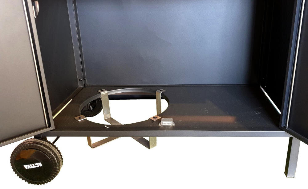 Wnętrze dolnej części grilla gazowego z widocznym miejscem na butlę gazową. Na kółku znajduje się napis \'VALCO\'.