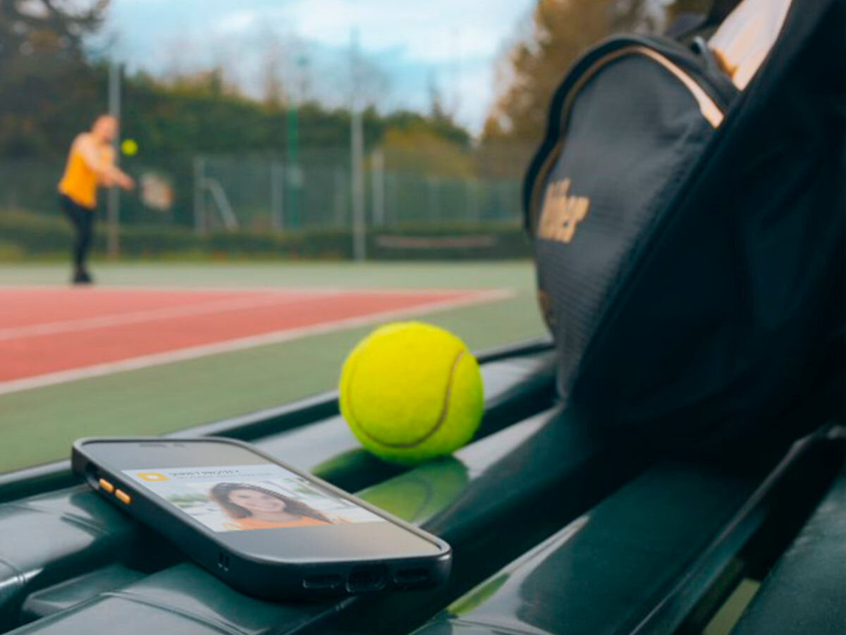 Zestaw wideodomofonowy SOMFY V350 Connect RTS Bezprzewodowy Wi-Fi, piksele, obraz, sieć, rts, temperatura, w tle osoba gra w tenisa ziemnego, na pierwszym planie smartfon z aplikacją somfy