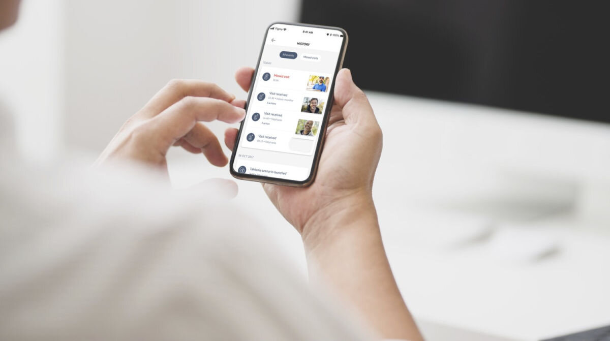 Zestaw wideodomofonowy SOMFY V350 Connect RTS Bezprzewodowy Wi-Fi, obraz, historia, micro-SD, scenariusze, osoba trzyma smartfon z aplikacją somfy