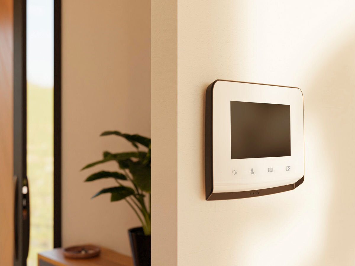 Zestaw wideodomofonowy SOMFY V350 Connect RTS Bezprzewodowy Wi-Fi, rts, dostęp, oświetlenie, funkcja, wideodomofon zamontowany na ścianie, w tle korytarz mieszkania