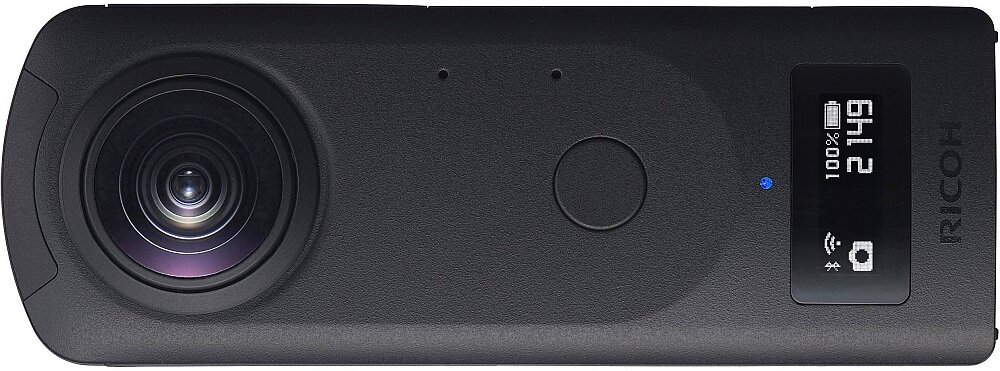 Czarna kamera sportowa z dużym obiektywem po jednej stronie i małym wyświetlaczem po drugiej. Na wyświetlaczu widoczny jest tekst: \'100% 2 14:9\', ikona Wi-Fi oraz ikona aparatu, a obok znajduje się logo \'RICOH\'.