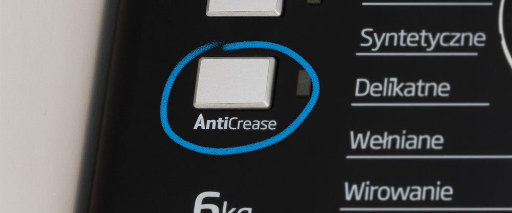 Panel pralki z przyciskiem oznaczonym jako \'AntiCrease\' otoczonym niebieskim okręgiem. Widoczne są również napisy: \'Syntetyczne\', \'Delikatne\', \'Wełniane\', \'Wirowanie\' oraz \'6kg\'.