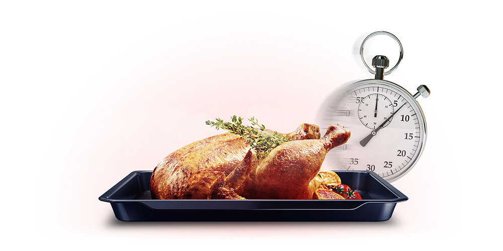 Na obrazie widoczny jest upieczony kurczak na czarnej blasze, ozdobiony gałązką ziół. Obok znajduje się stoper z widocznymi cyframi, wskazujący czas.